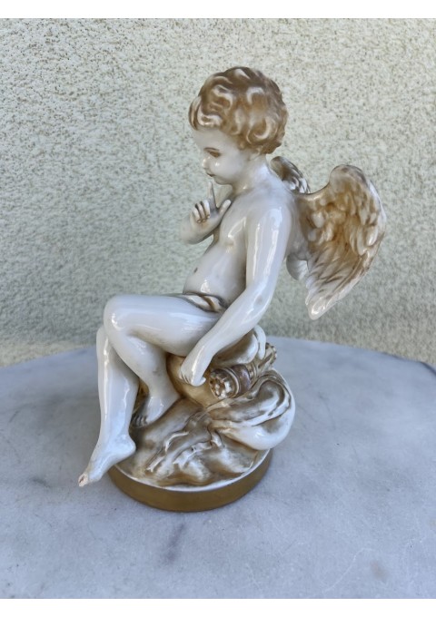 Statulėlė, skulptūrėlė Sėdintis kupidonas, pagal Etienne-Maurice Falconet (1716–1791) skulptūrą. Prancūzija, Vokietija. Porcelianas, monochrominė tapyba, auksavimas. XIX a. pr. Kaina 87