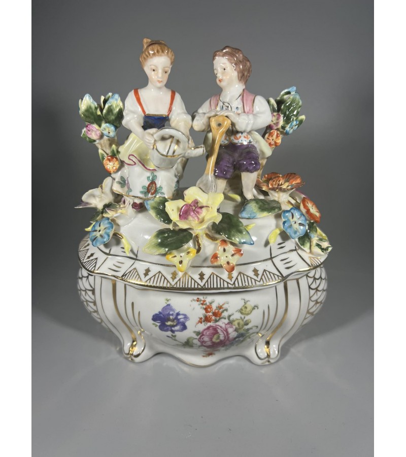 Dėžutė porcelianinė puošta gėlėmis bei figūrėlėmis. Kaina 63