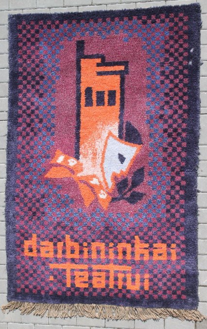 Kilimas sieninis su Kauno vaizdu, autorinis, Jūratės Petruškevičienės austas kilimas: Darbininkai teatrui. Išlikusi autorės gaminio etiketė. Dydis: 200 X 132 cm. Kaina 387