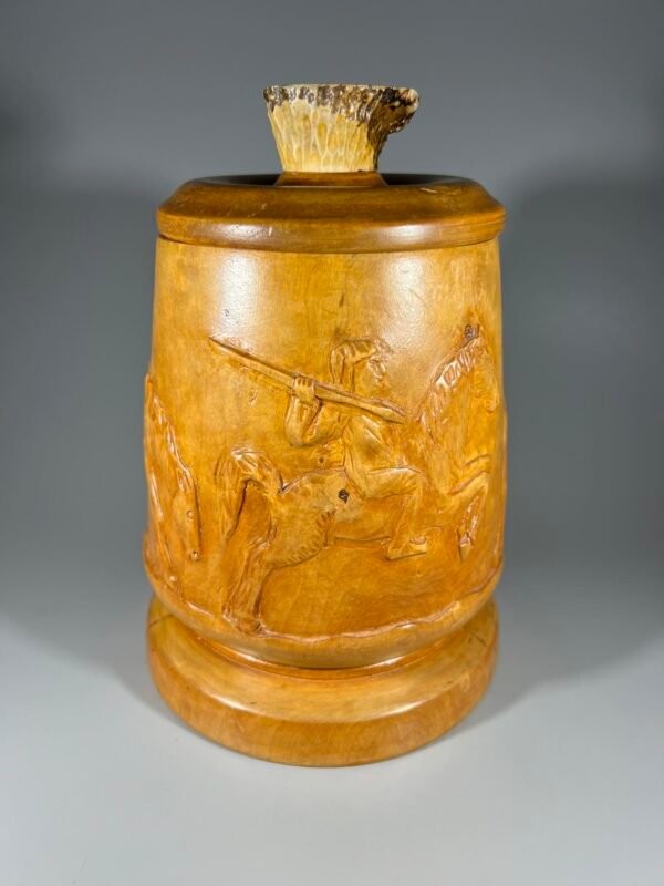 Dėžutė medinė, antikvarinė, cilindro formos, rago rankenėle, puošta reljefiniu raiteliu. Kaina 43