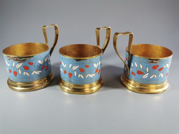 Podstakanikai, stiklinių laikikliai tarybiniai, puošti emale. Kiek nutrupėjęs vienos pusės kraštelio emalis. 3 vnt. Kaina po 13