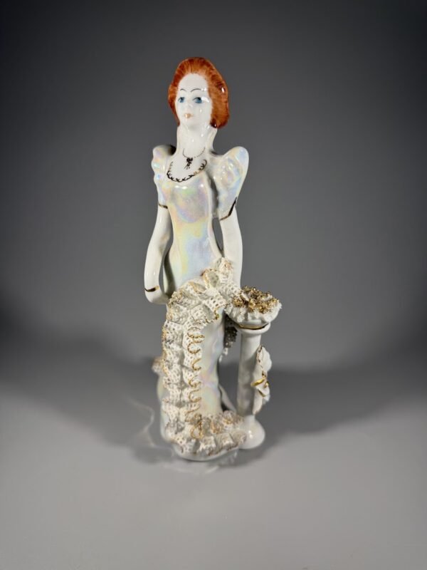 Vintažinė porcelianinė statulėlė „Dama su nėriniuota suknele“ (M. Debelly, Rumunija, 20 cm.)